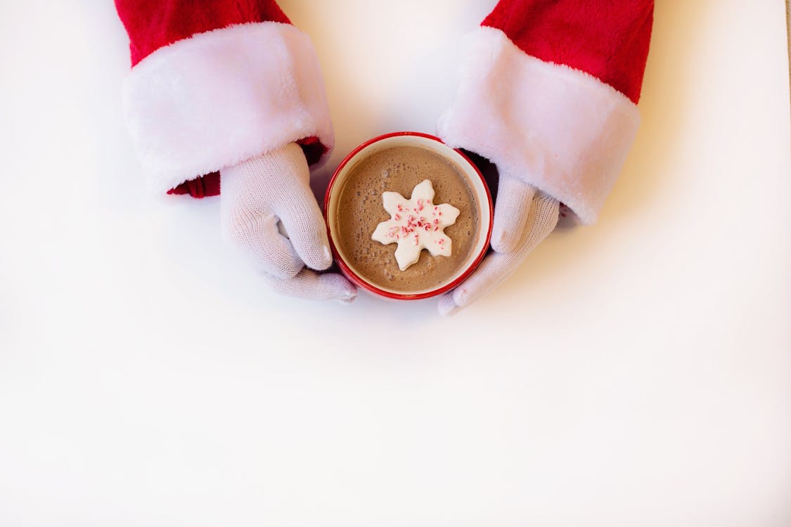 Person Wearing White Gloves Holding Cup of Hot Cocoa