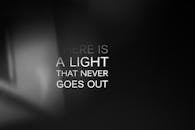 励志名言“有一盏永不熄灭的光”印在黑色渐变背景上