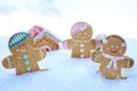 三个姜饼人在雪中庆祝欢乐的冬季