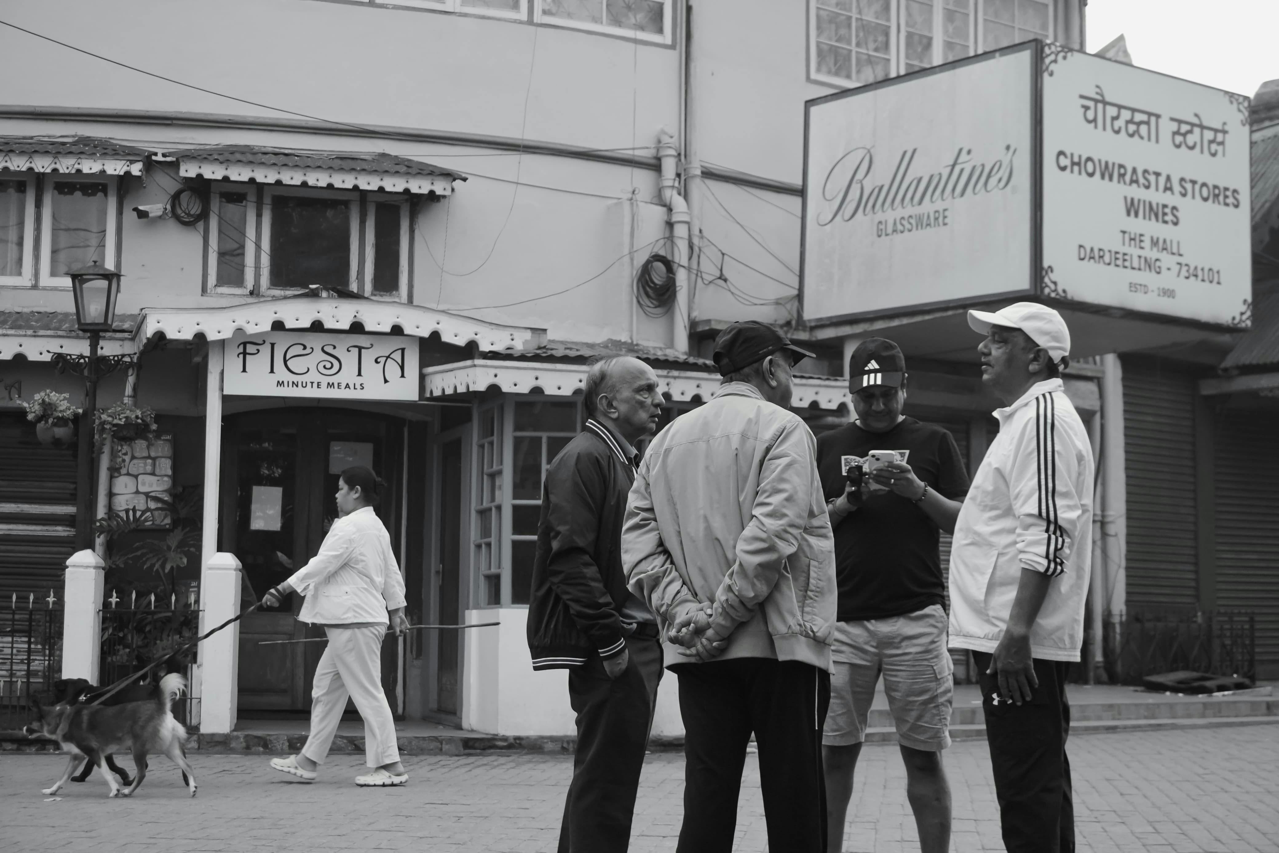 Free A candid street scene capturing locals engaged in morning conversation in Darjeeling's famous Chowrasta. Stock Photo