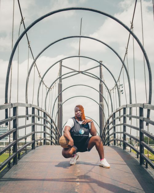 Free Athletic young man posing with basketball on a modern bridge. Stock Photo