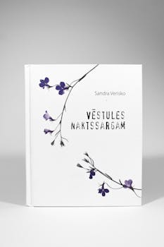 Hardcover book 'Vēstules Naktssargam' with delicate floral design on white background.