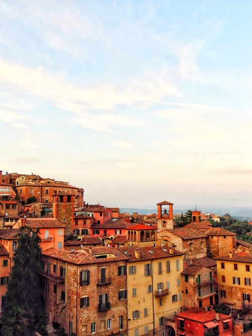 Free Picturesque Italian village with charming rooftops at sunset, showcasing rustic architecture. Stock Photo