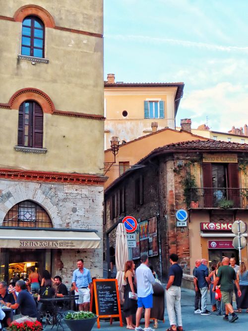 Free People enjoying a vibrant evening at a cafe in a historic European town square. Stock Photo