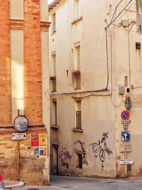 Free A picturesque narrow street in an Italian village with graffiti and posters. Stock Photo