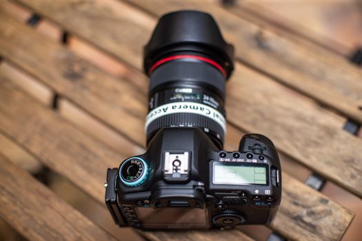 Top view of a professional DSLR camera placed on a wooden surface, perfect for photography enthusiasts.