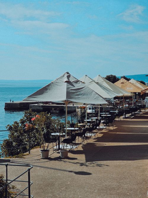 Free Scenic outdoor cafe with umbrellas by the sea in Rijeka, Croatia. Stock Photo