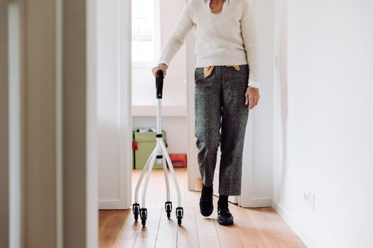Senior adult walking indoors with a rollator, promoting mobility and independence