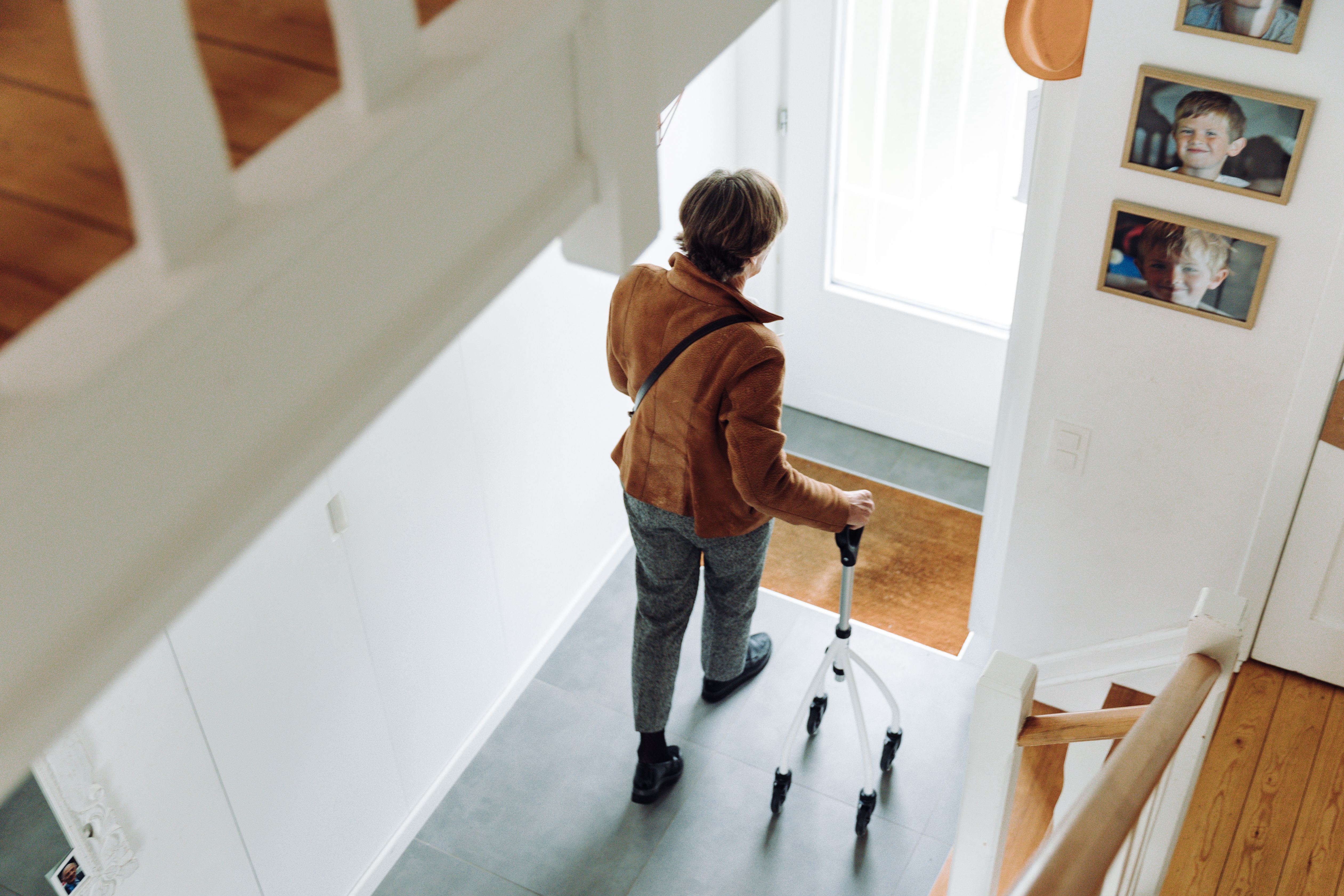 A senior adult walking indoors with a rollator, depicting independence and mobility