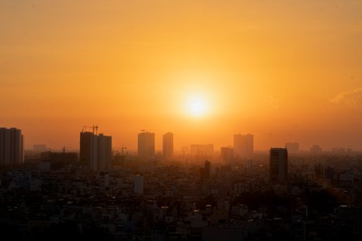 Golden hour view of Ho Chi Minh City's urban skyline with a beautiful sunset silhouette.