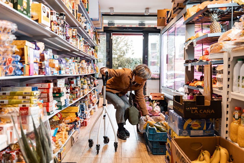 Senior woman using rollator shopping for produce in grocery store aisle.