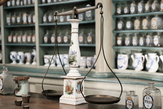 Close-up of antique scales and medicine bottles in a vintage pharmacy setting.