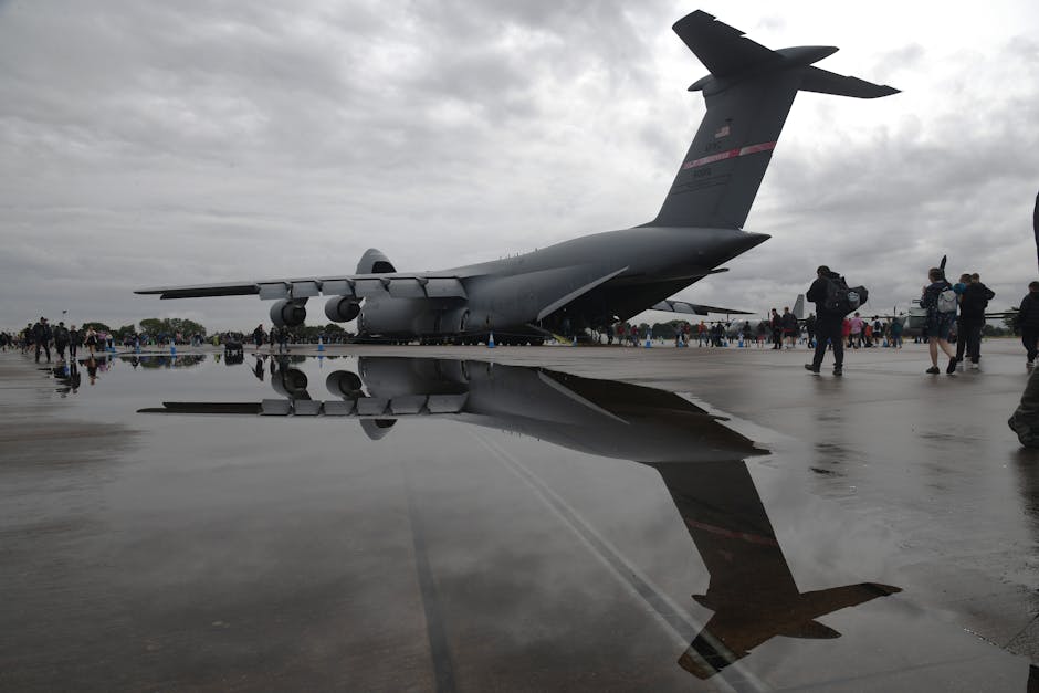 Stunning reflection of a military aircraft at an airshow in England, under cloudy skies.