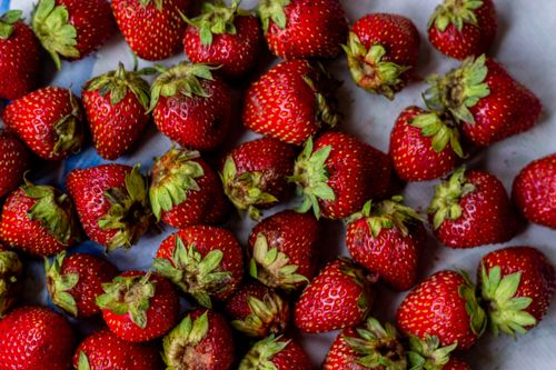 Free Vibrant flat lay of newly picked strawberries showcasing their freshness and texture. Stock Photo