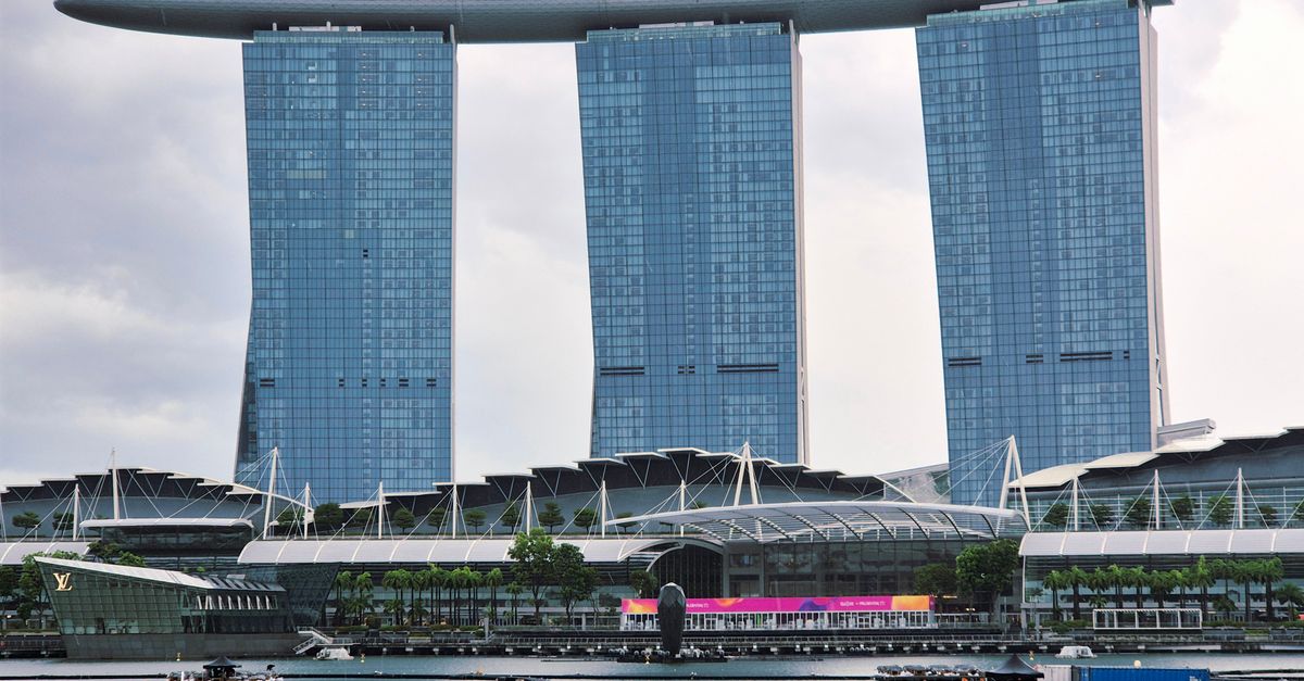 Marina Bay Sands hotel and the Singapore skyline reflected in the water at night with city lights