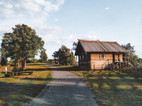 Free Idyllic wooden cabin surrounded by nature in Karelia, Russia under a warm sunset glow. Stock Photo