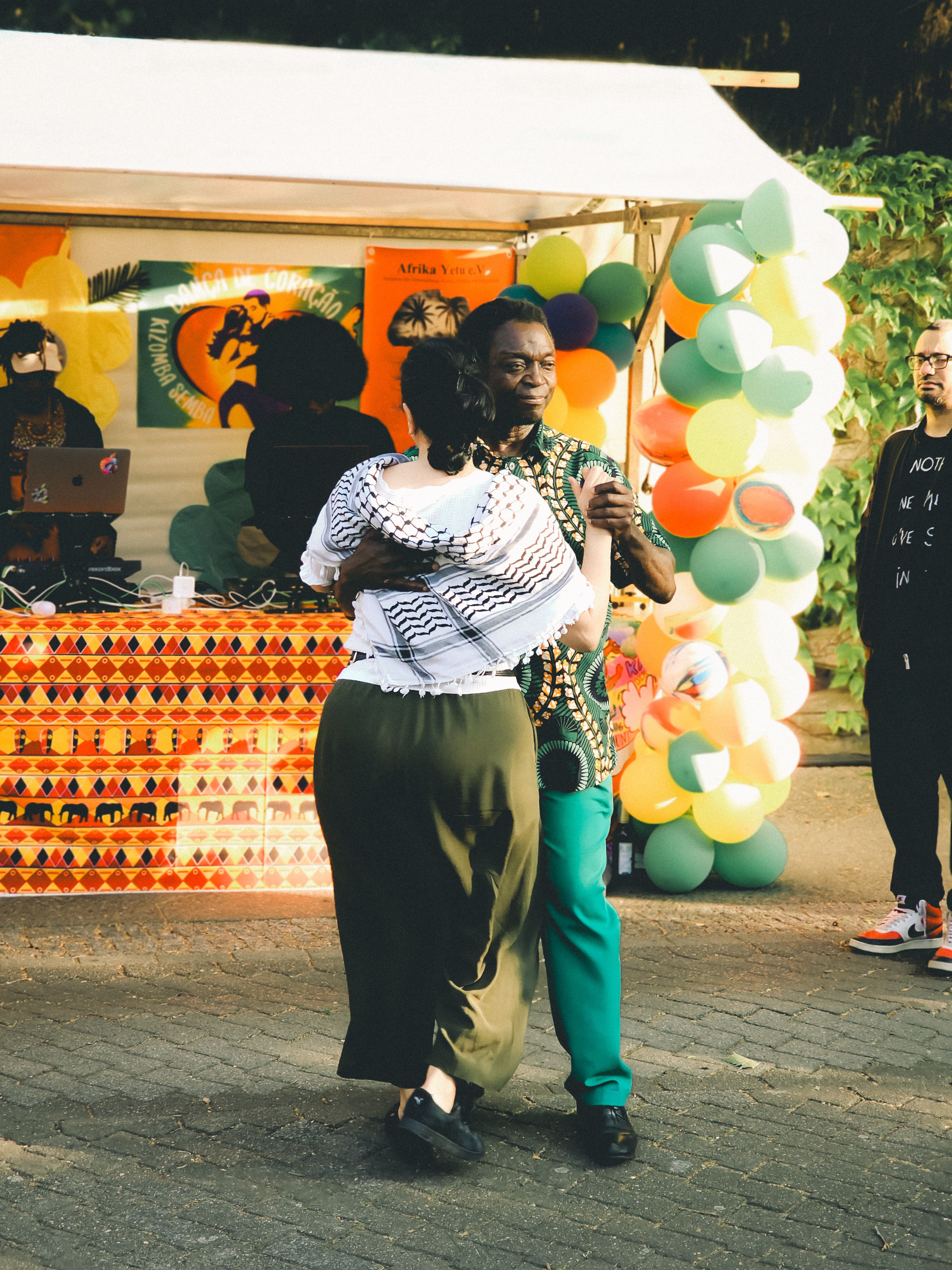 Couple dancing at an Afro-themed party in Berlin with colorful balloons and decorations. — Kizomba & kuduro, Portugal.