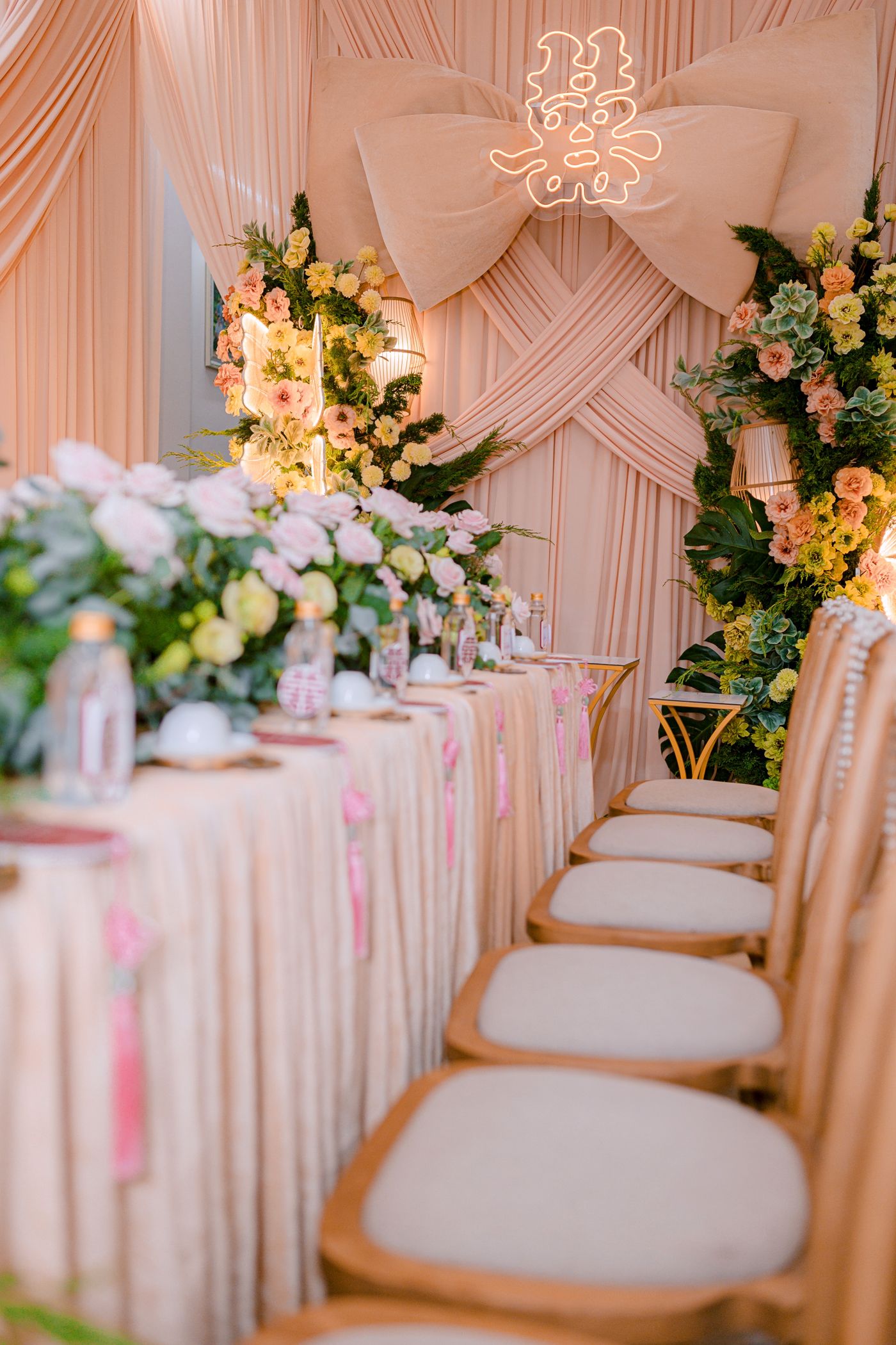 Elegant wedding celebration table with floral arrangements and a fabric backdrop