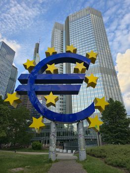 The Euro sculpture stands tall amid Frankfurt's modern skyscrapers, symbolizing financial strength.