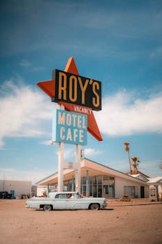 Vintage view of Roy's Motel and Café sign with classic car on Route 66.