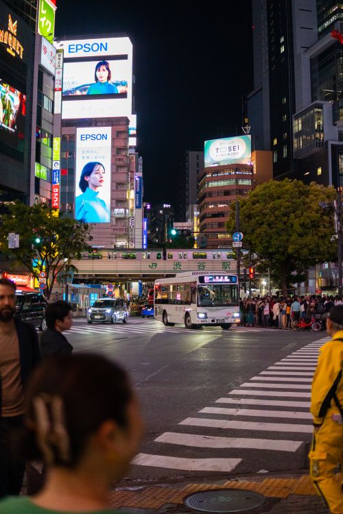Free Bustling night scene at Shibuya Crossing, Tokyo, showcasing vibrant neon lights and busy pedestrian activity. Stock Photo