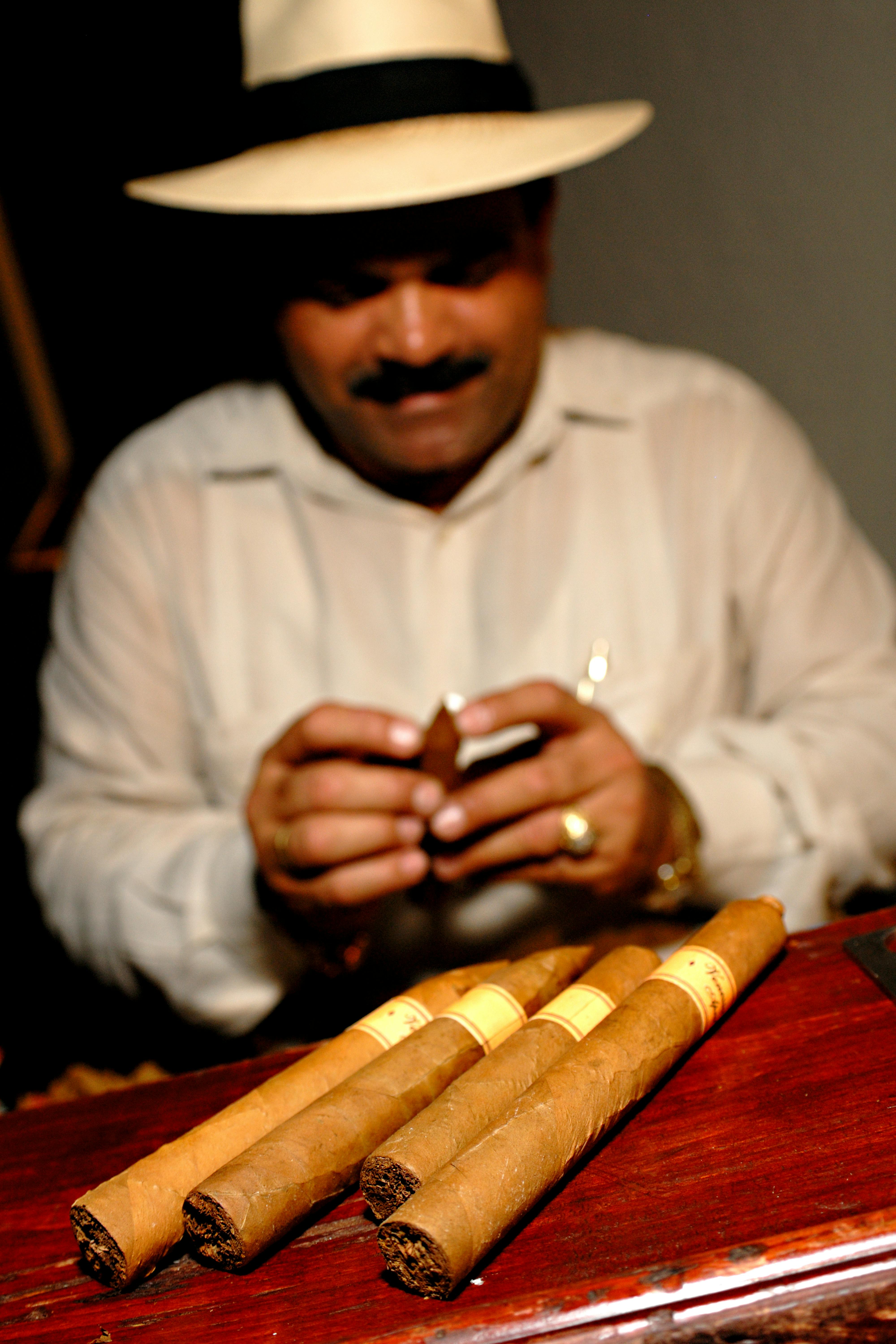 Artisan rolling Cuban cigars in a traditional setting, showcasing craftsmanship.