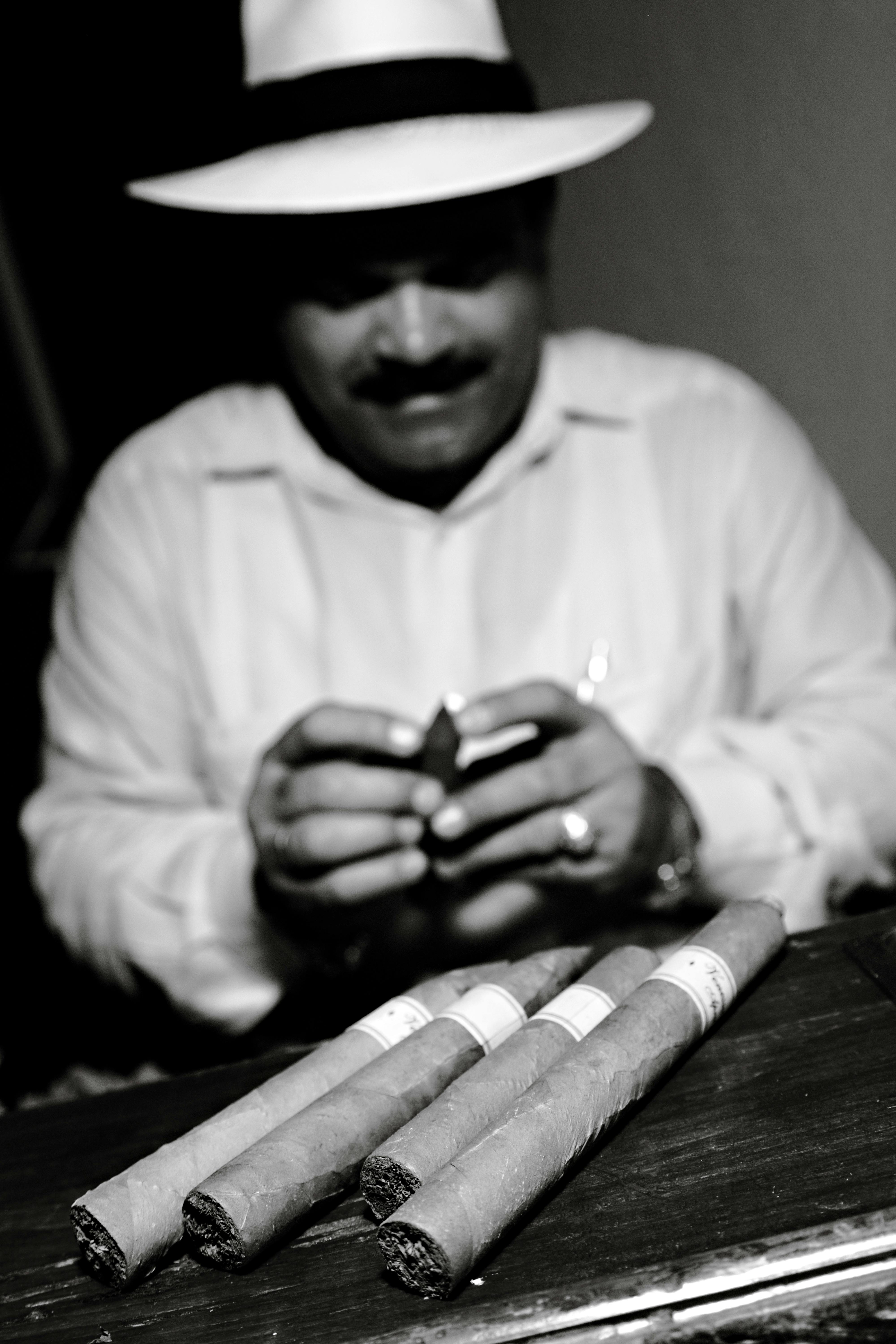 A skilled craftsman meticulously rolling cigars in Cuba, showcasing traditional cigar-making techniques.