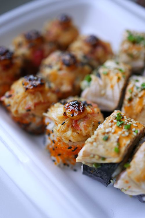 Free Close-up of assorted sushi rolls with unique toppings and garnishes. Stock Photo