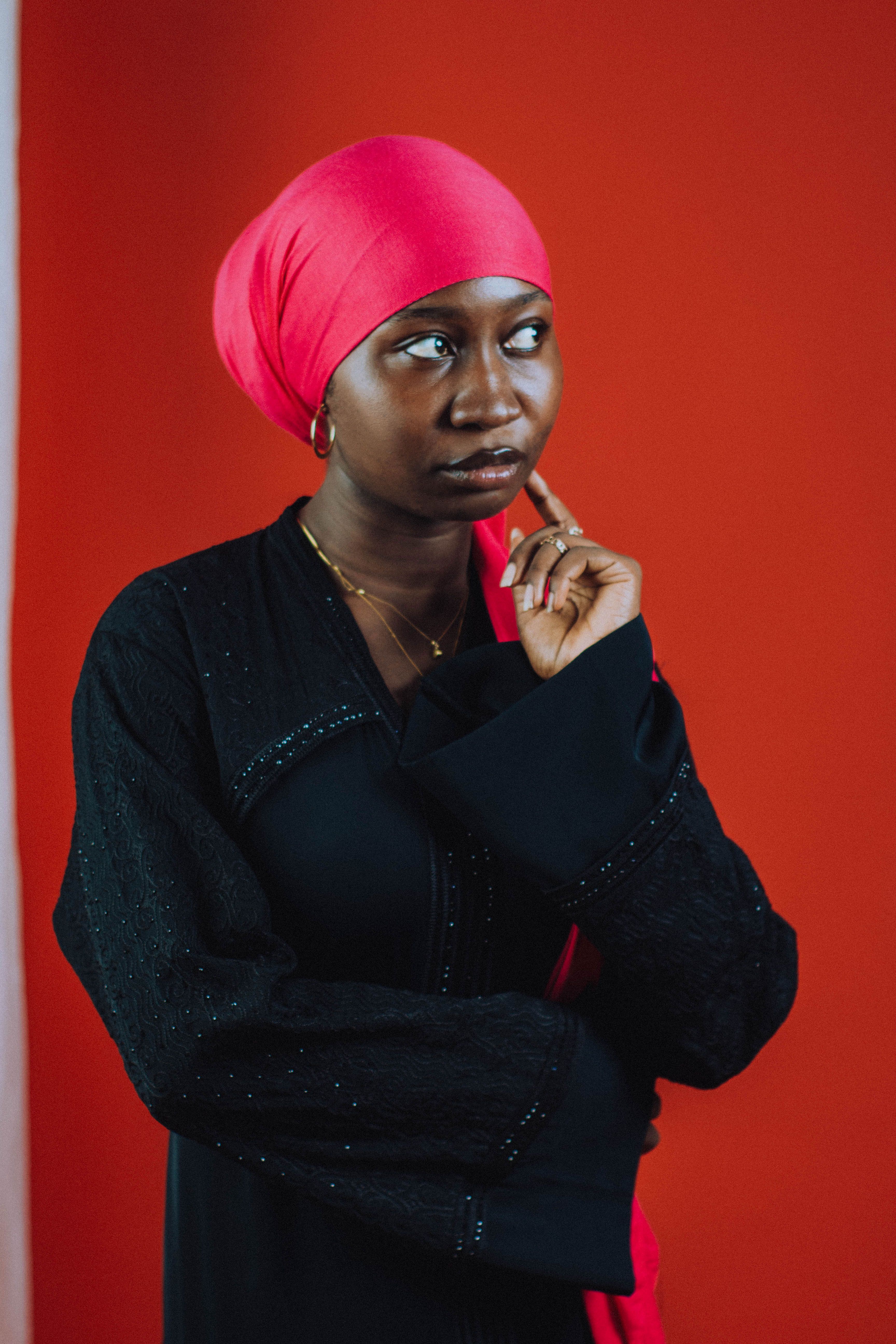Elegant Woman in Pink Hijab Against Red Background · Free Stock Photo