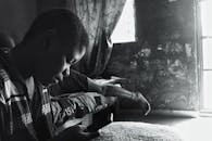 一个深思熟虑的人坐在单色环境中，映衬出孤独与内省