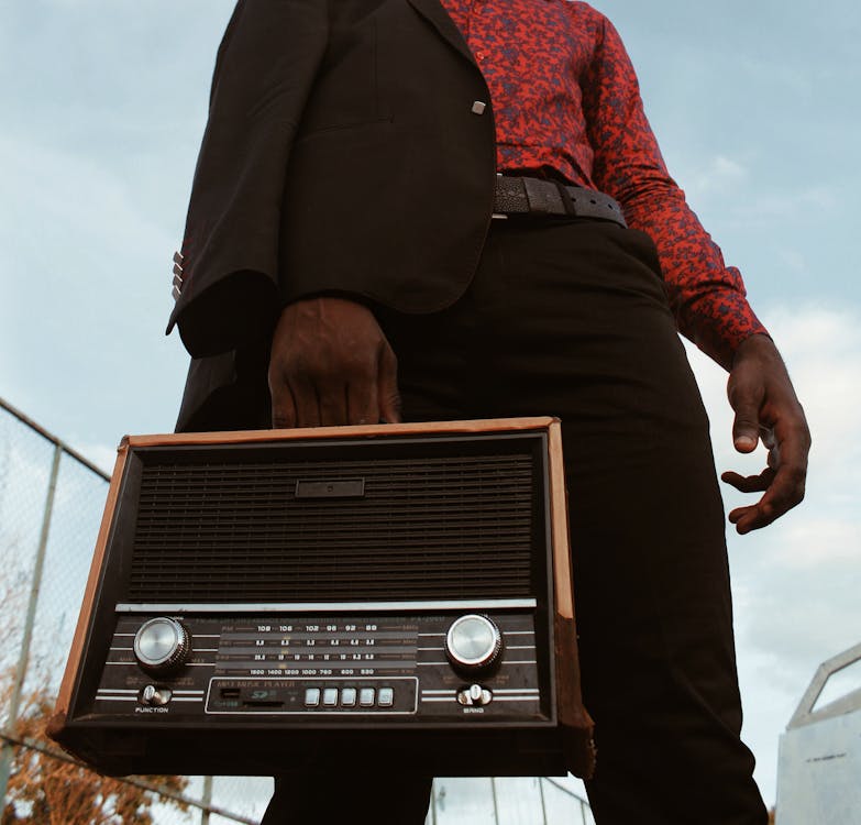 Низкоугловая фотография человека с коротковолновым радиоприемником