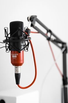 Close-up of Scarlett Studio CM25 microphone on boom arm in a professional setup.