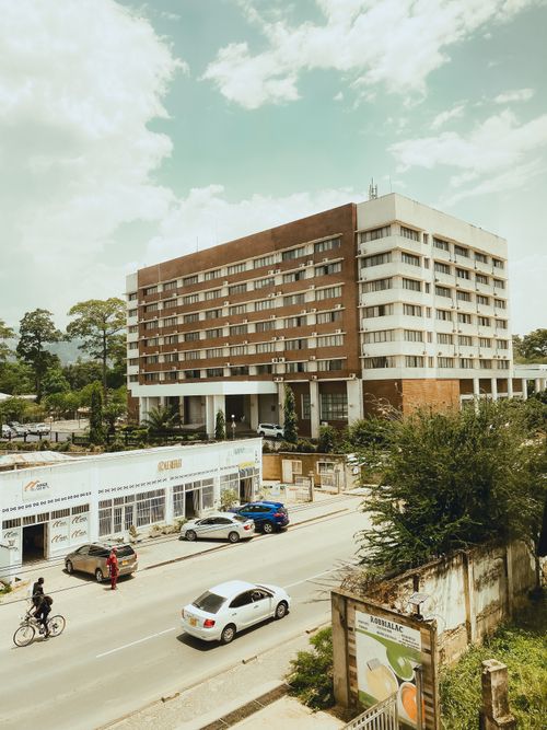 Free City street view with modern building, cars, and bicycles on a sunny day. Stock Photo