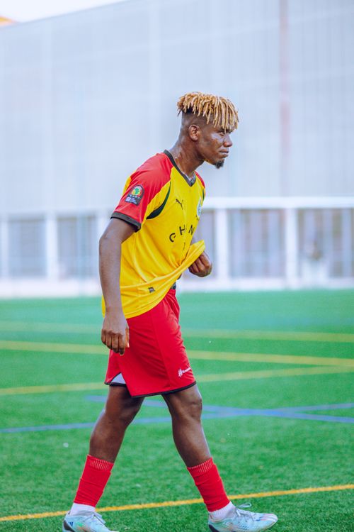 Free Male soccer player on outdoor field wearing vibrant red and yellow uniform. Stock Photo