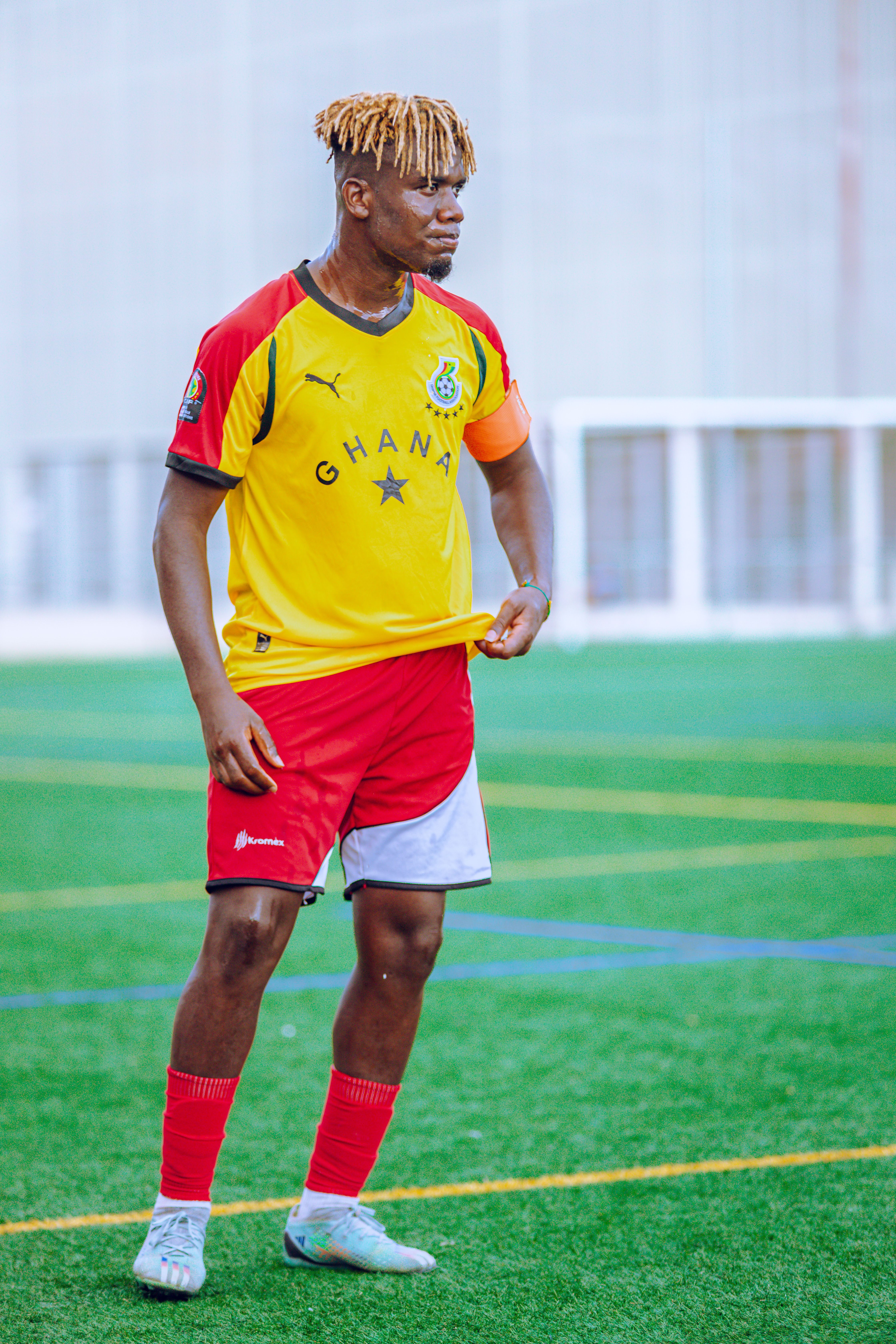 Male soccer player in Ghana team uniform on a football field.