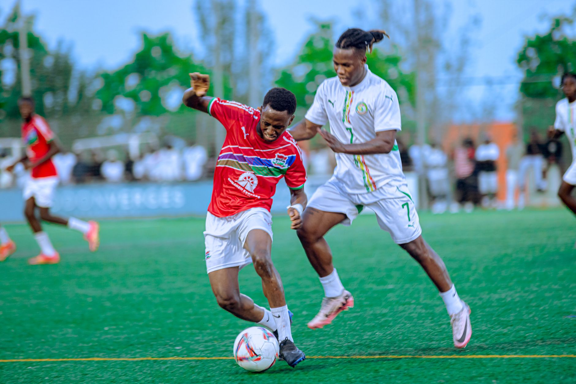 Two players competing intensely during a soccer match on a vibrant green field.