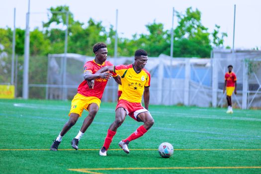 Players engage passionately in a soccer match on an outdoor field, showcasing athleticism and team spirit.