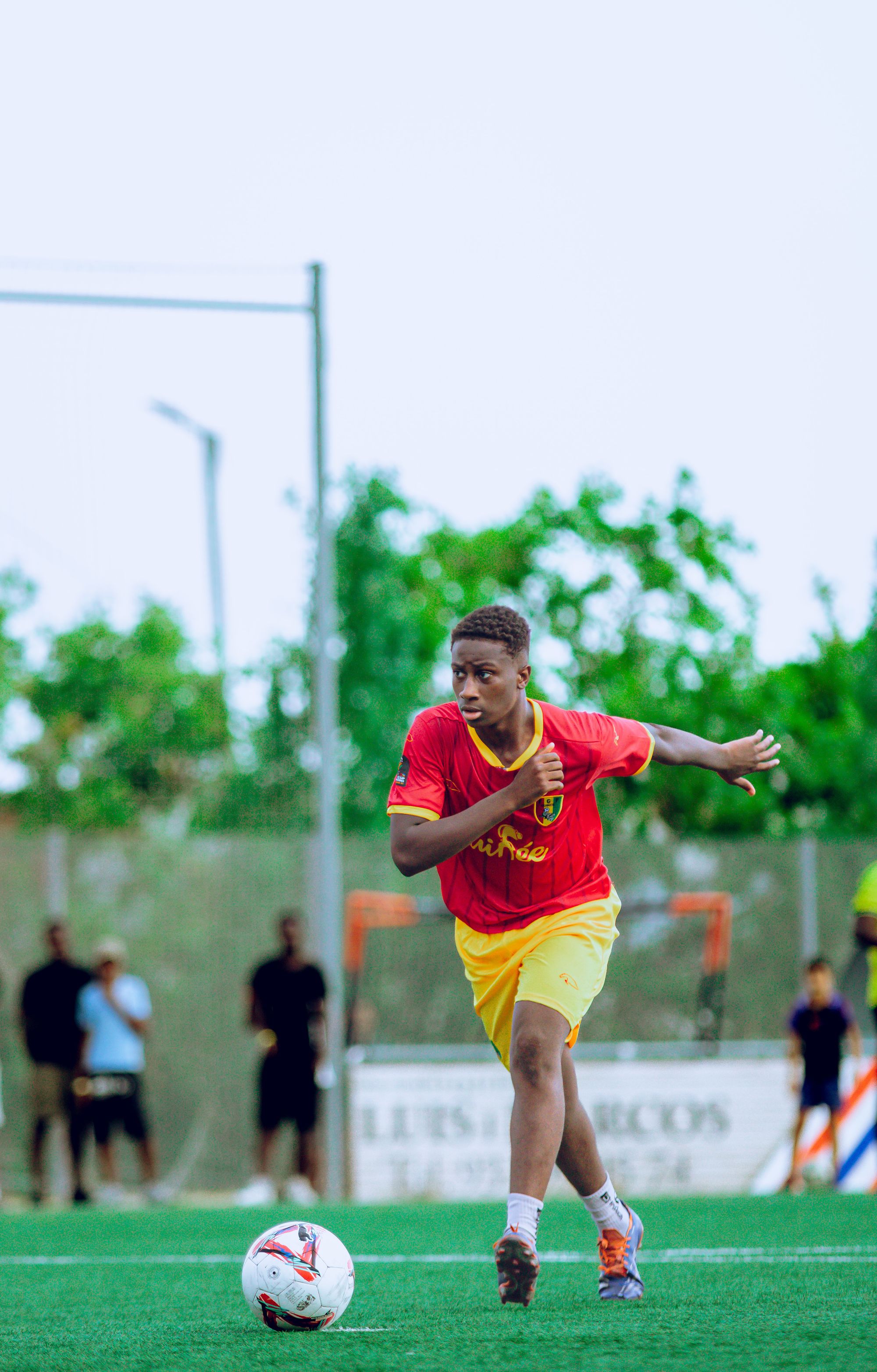 Soccer player driving forward with the ball in full-body match action
