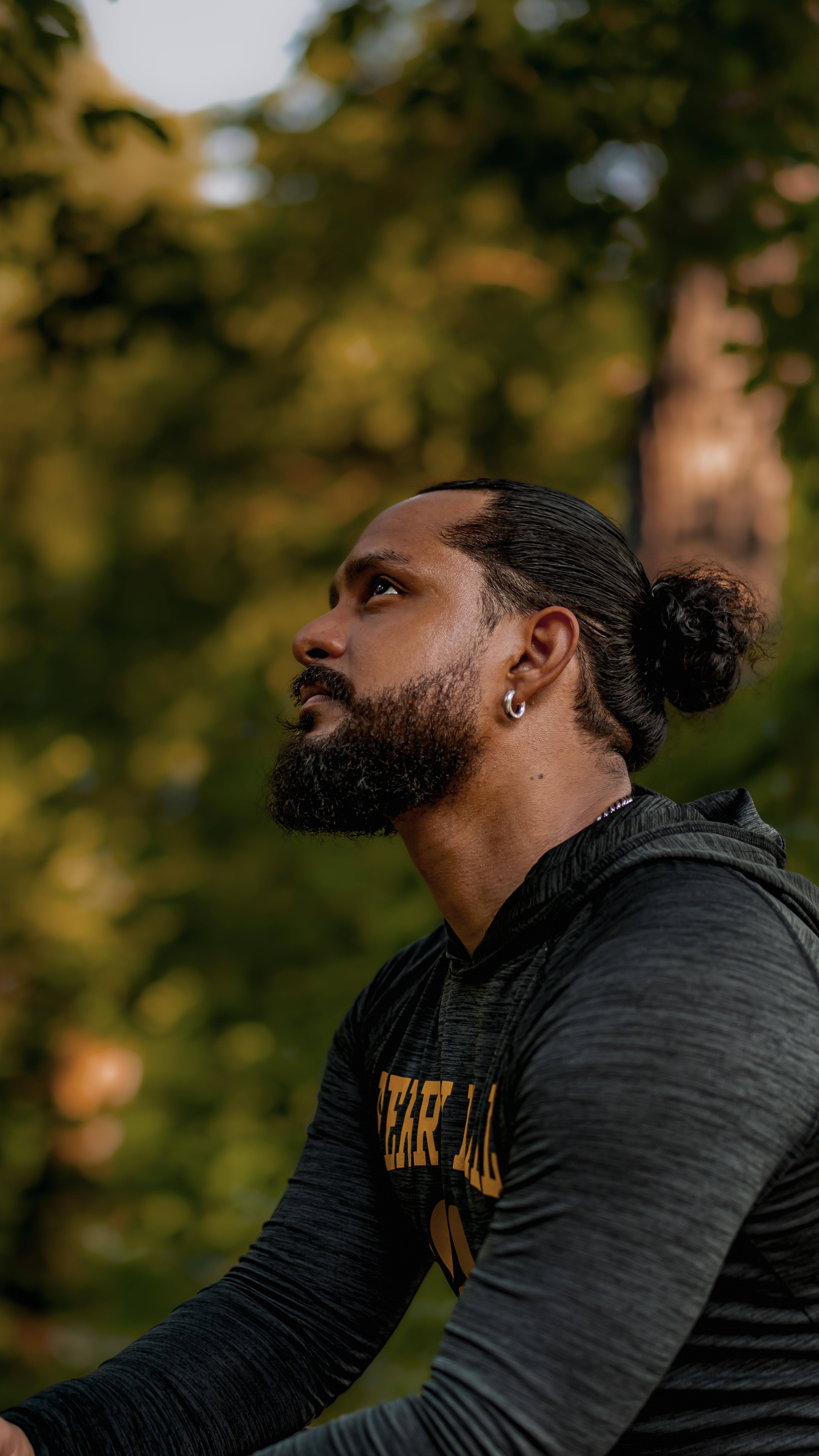 Contemplative man outdoors in lush park, capturing a serene moment in early fall in Washington D.C.