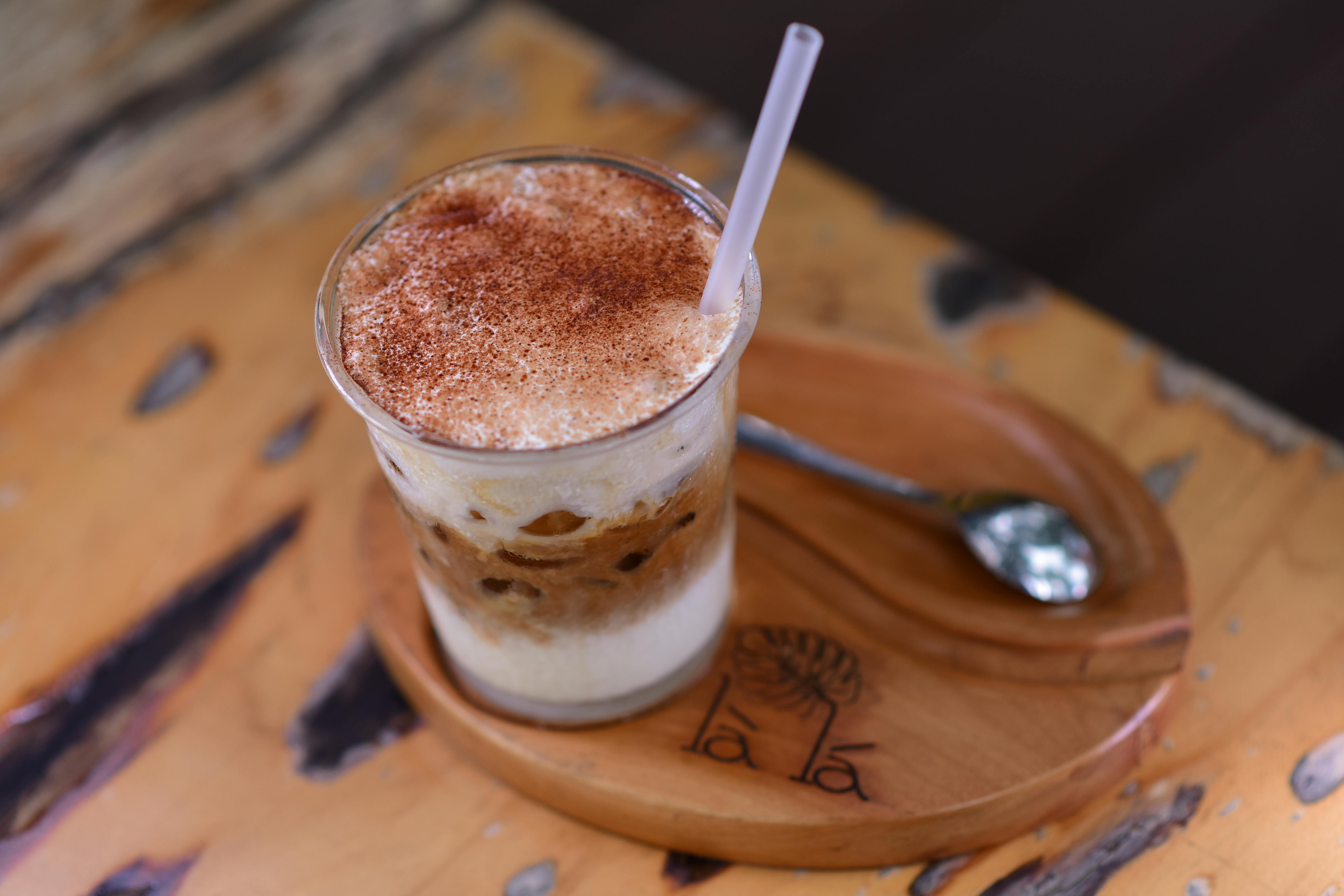 A close-up iced coffee with cream and cinnamon, showing how easily horchata can be reduced to a café flavour note