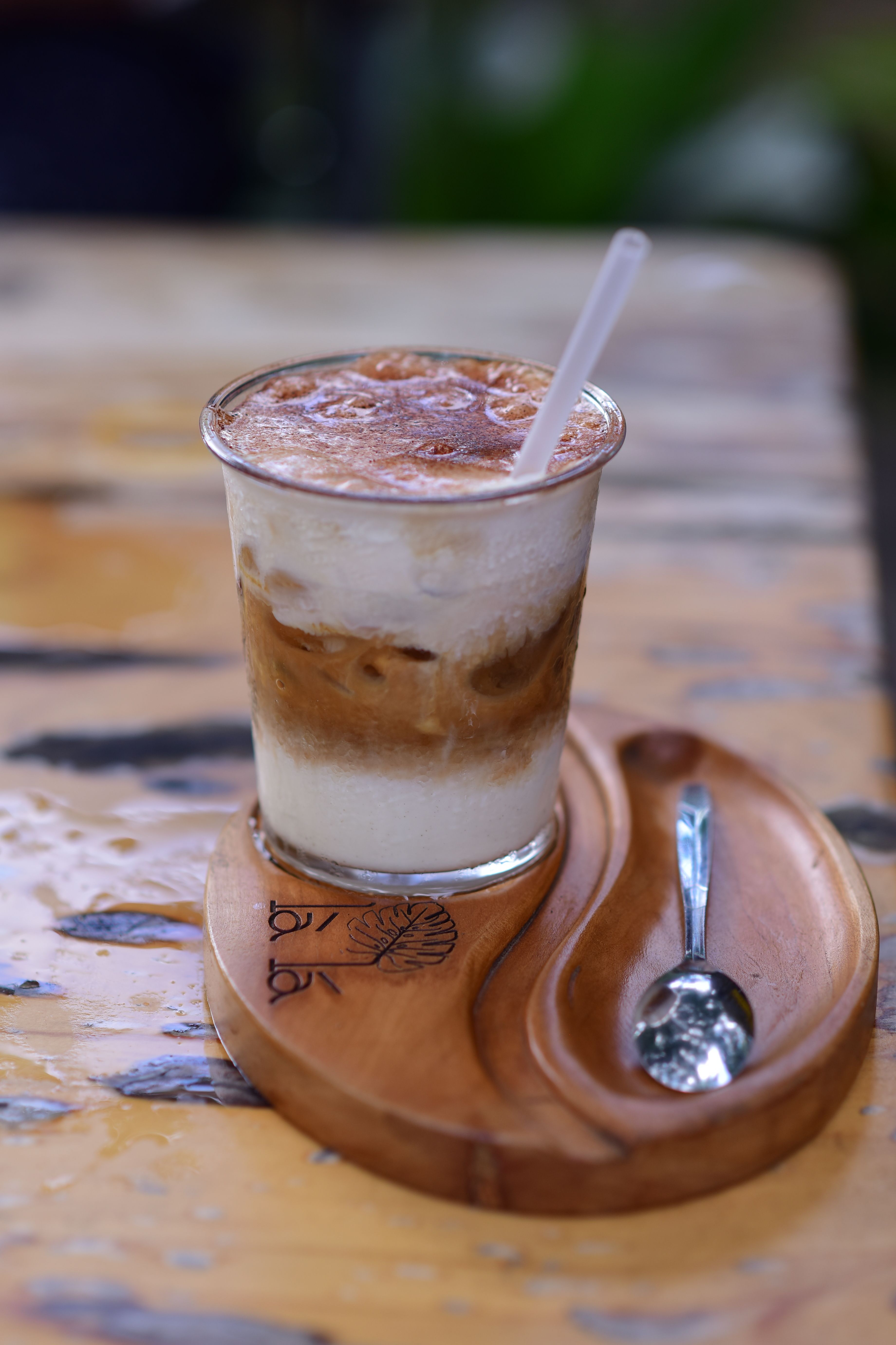 A delicious iced coffee with milk served on a handcrafted wooden tray, perfect for coffee lovers.