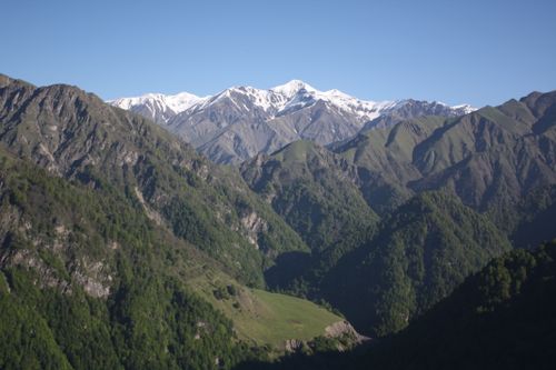 Free A stunning view of snow-capped mountains under a clear blue sky. Stock Photo