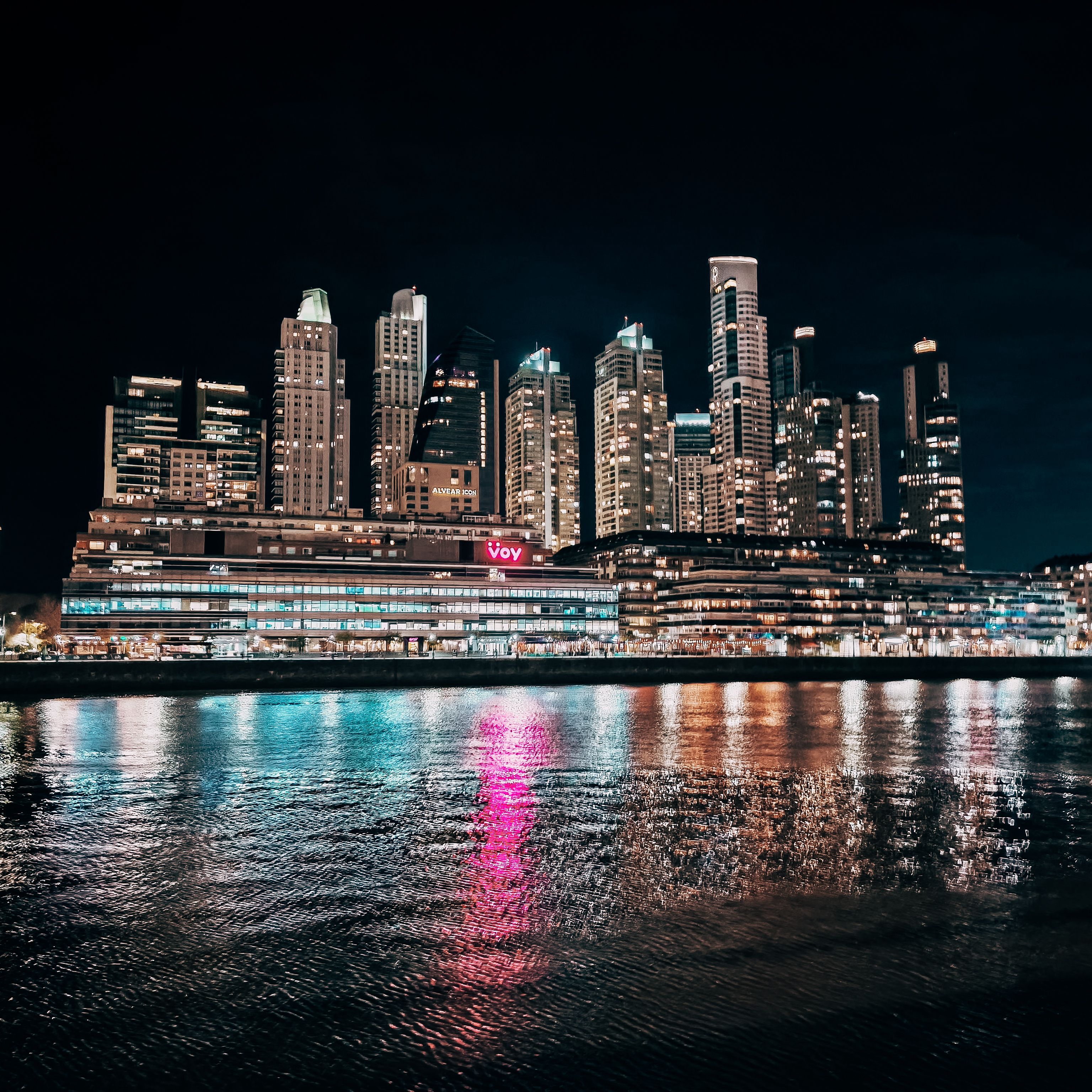 Illuminated City Skyline Reflecting on River · Free Stock Photo