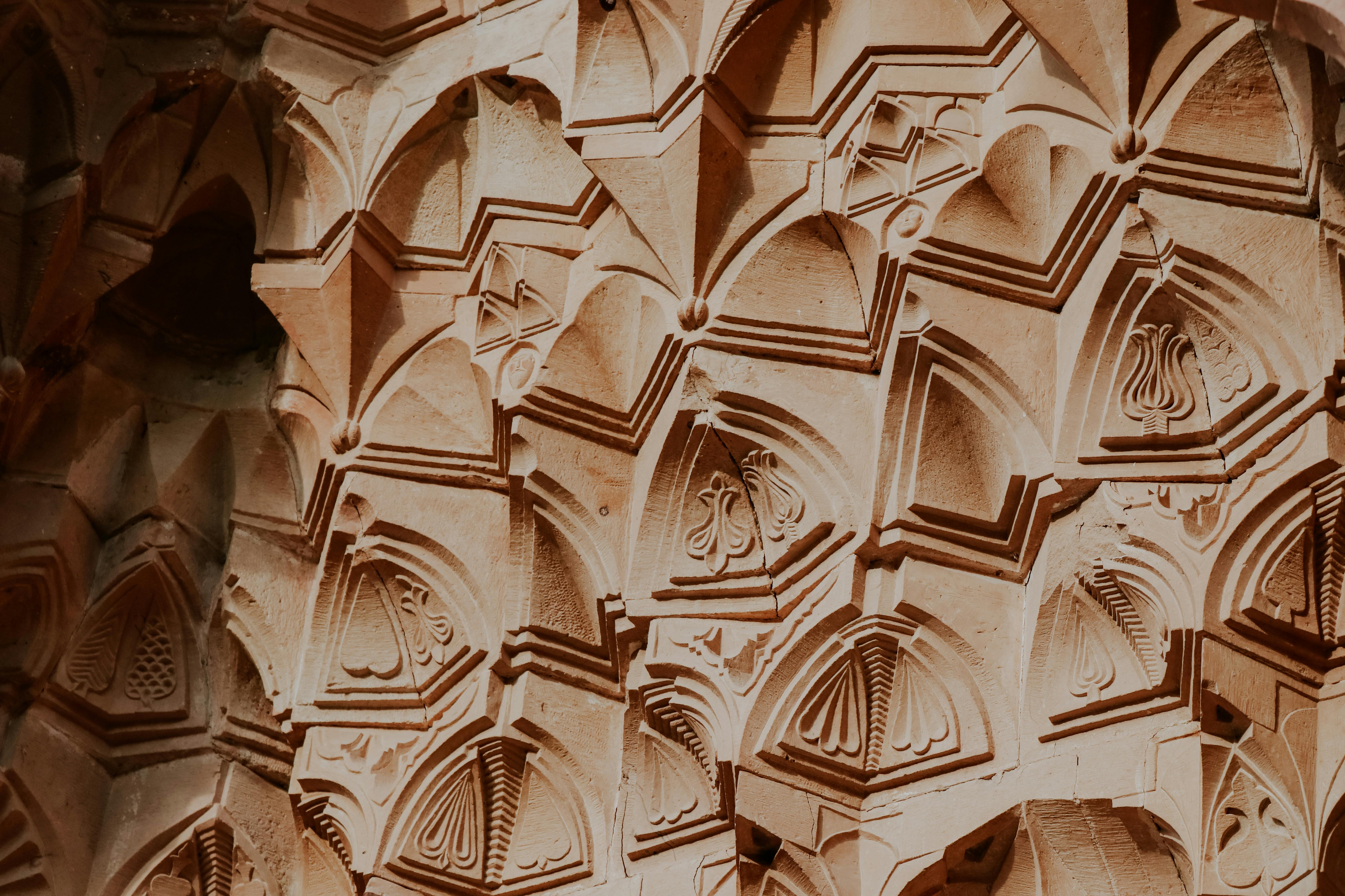 Close-up of decorative and intricate geometric carvings on a historical archway, showcasing artistic craftsmanship.