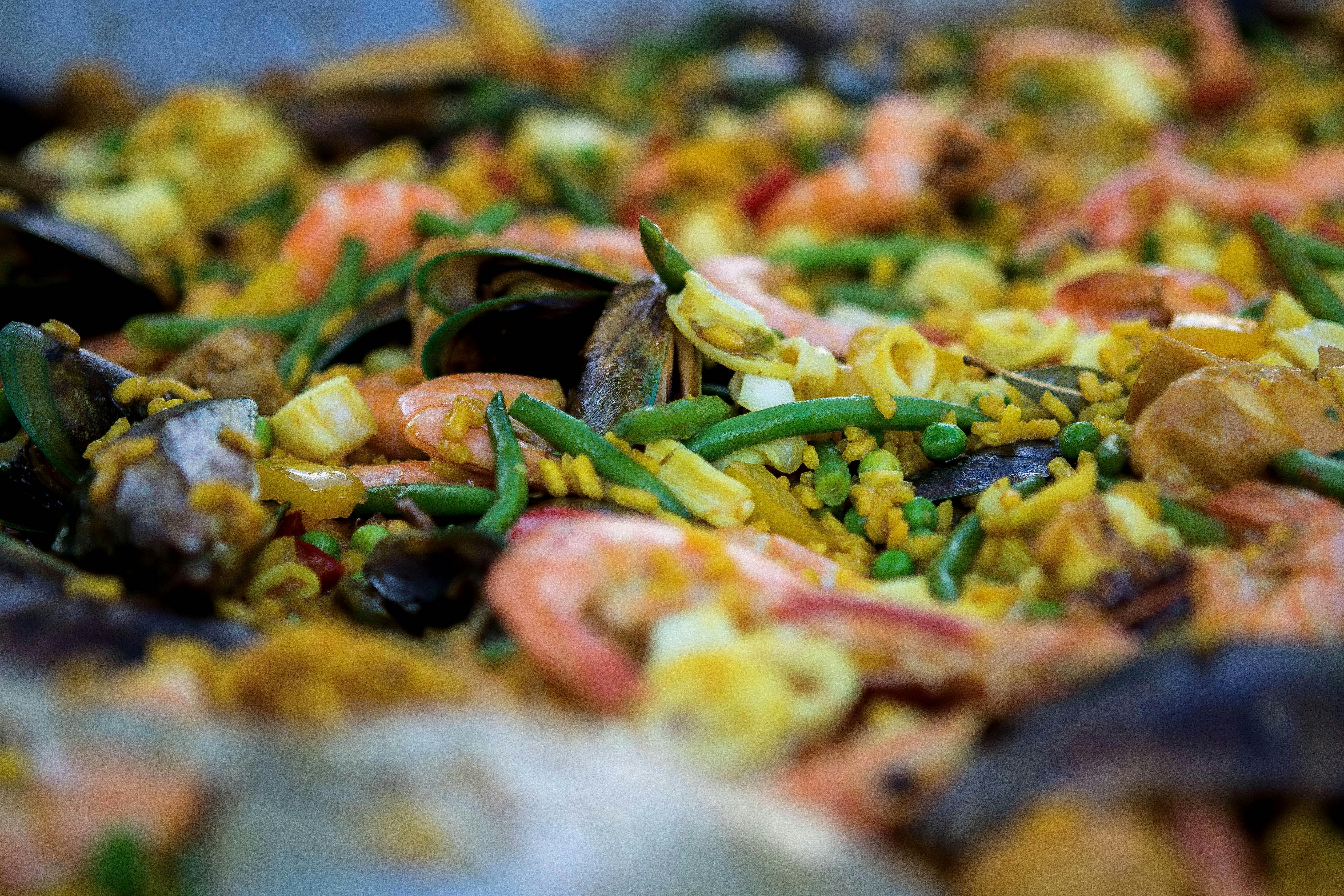 A vibrant, colorful plate of authentic Spanish paella with fresh seafood and vegetables. - authentic travel company