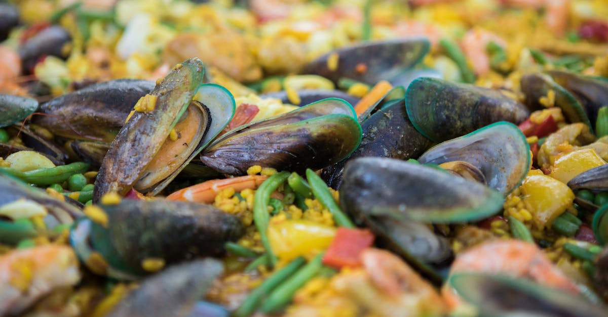A pitcher of red sangria with slices of oranges, apples, and strawberries, garnished with fresh mint leaves, sitting on a wooden table.
