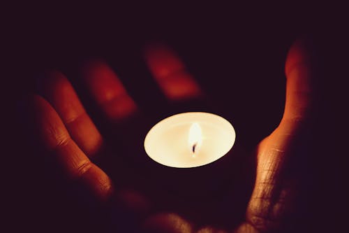 Lighted Tealight on Person Palm