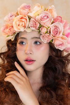 Close-up portrait of a woman wearing a pink rose floral crown with a soft background.