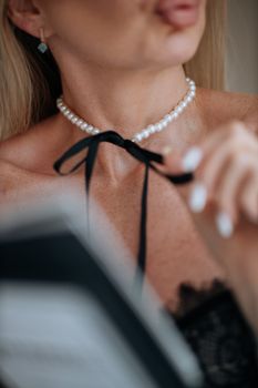 Close-up of a woman wearing a pearl necklace and lace outfit, evoking elegance and sophistication.