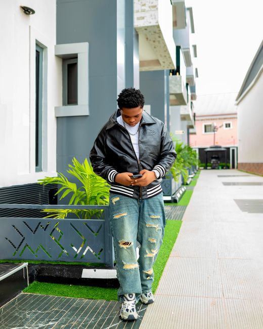 Casual young adult checking smartphone outdoors in modern urban environment. Casual young adult checking smartphone outdoors in modern urban environment.